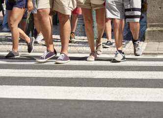 Many people walking in the city center of Porto. Pedestrians crossing the busy street on the pedestrian crossing in the city center of Porto, Portugal