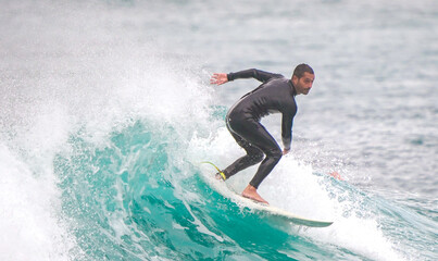 Surfer ride waves in slow motion at Las Canteras beach in Las Palmas de Gran Canaria