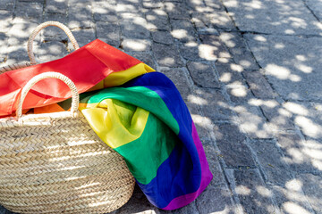 LGBT rainbow flag in a wicker basket on the ground. Gay parade, freedom, tolerance