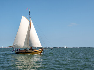 Fototapeta premium Traditional classic sailboat sailing under full sails on IJsselmeer lake, Netherlands