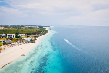 The picturesque Nungwi beach in Zanzibar, Tanzania is showcased in a toned aerial view image,...