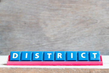 Obraz premium Tile alphabet letter with word district in red color rack on wood background