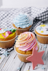 Multiple colorful nicely decorated muffins on a wooden background
