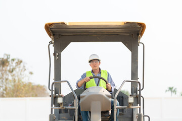 Fototapeta na wymiar Construction engineers and foreman worker working at construction site, worker driving tractor for survey the project.