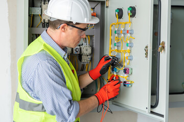Electrician installing electrical wires and multimeter fuse switch box in hands of electrician detail