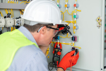 Electrician installing electrical wires and multimeter fuse switch box in hands of electrician detail