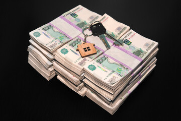 Banknotes of Russian rubles and keys to the apartment on black table. Estate sale. The deal for the sale of apartment. Concept.