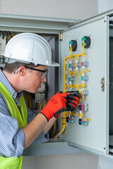 Electrician installing electrical wires and multimeter fuse switch box in hands of electrician detail