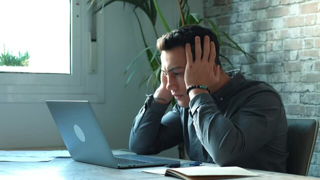 Tired male student or worker sit at home office desk look in distance having sleep deprivation, lazy millennial man distracted from work feel lazy lack motivation, thinking of dull monotonous job
