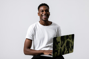 Happy african ameircan trader buisnessman programmer student with new modern laptop in hands standing over grey background in studio isolated working studying smiling looking at camera.
