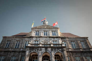 Obraz premium Main tower of the stadhuis maastricht, the Maastricht city hall, during a sunny afternoon sunset with blue sky. It's one of the main landmarks of the city, designed in the 17th century by Pieter Post.