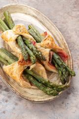 Baked green asparagus with bacon ham and cheese in puff pastry