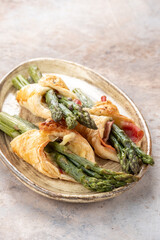 Baked green asparagus with bacon ham and cheese in puff pastry