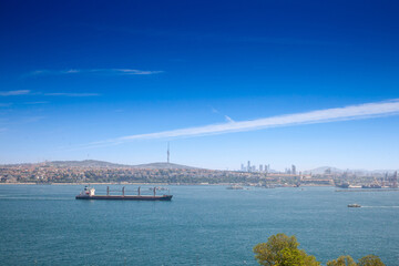 Fototapeta premium Panorama of Haydarpasa port with its cargo terminal and a supertanker ship, a large boat, sailing on the bosphorus strait in Istanbul, Turkey, passing from Mediterranean to the black sea.