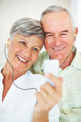 Smiling mature couple listening music together. Closeup of smiling mature couple listening music together at home.