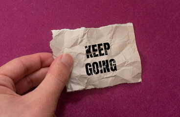 'Keep Going' written on paper. Motivation concept background photo.