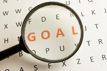 The view through the magnifier focus on "GOAL" word highlighted in red color use for Goal Achievement and Purposefulness,challenge in business concept.