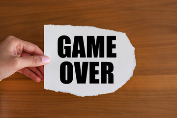 Game over. Woman hand holds a piece of paper with a note. Leisure games and activities, finishing, end, strategy and video games.