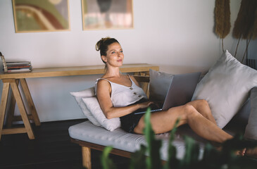 Content woman surfing internet on laptop at home