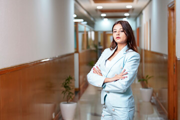 Young and confident corporate woman standing at office.