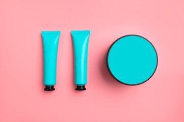 Cosmetic bottles template mockup. Emerald clean packaging for cream lotion body scrub gel on pink background top view. Cosmetics for branding, logo application. Beauty, skincare, spa, fashion