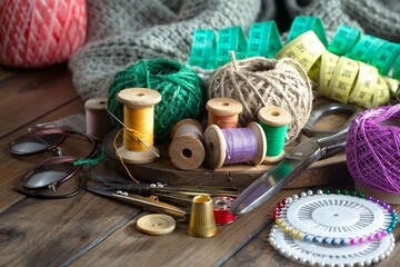 Colored threads and items for sewing, on an old background.