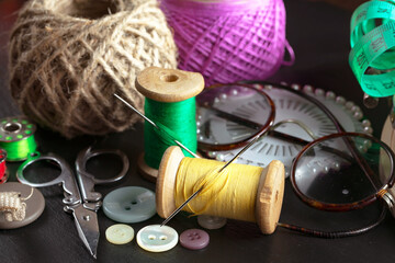 Colored threads and items for sewing, on an old background.