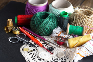 Colored threads and items for sewing, on an old background.