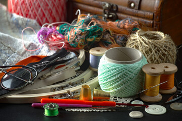 Colored threads and items for sewing, on an old background.