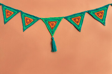 Triangle crochet flags in green and orange colors on orange back