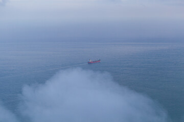 Fototapeta premium Boat on the ocean water and clouds