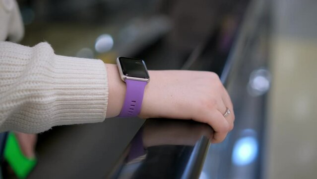 Moll. A young woman in a shopping mall stands on an escalator. 4K