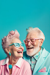 Cheerful senior Caucasian couple in colorful extravagant outfits and glasses with gray hair smiling against turquoise background. Generative AI. - obrazy, fototapety, plakaty