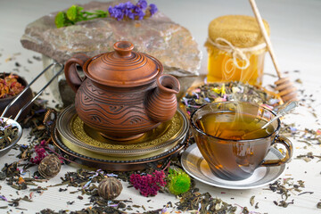 Sweet, hot tea with dry tea leaves, on an old background.