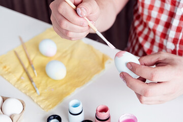 Obraz na płótnie Canvas man coloring easter eggs at home kitchen