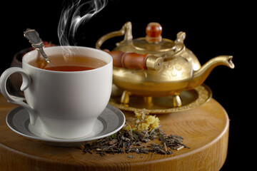 Hot sweet tea in a cup on old background