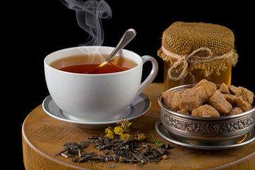 Hot sweet tea in a cup on old background