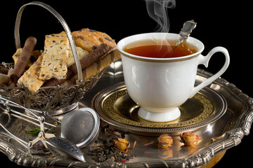 Hot sweet tea in a cup on old background