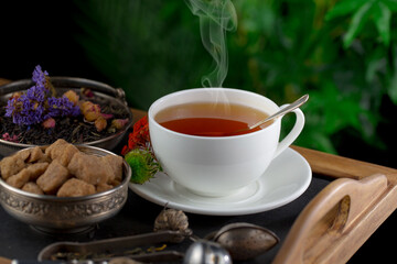 Obraz na płótnie Canvas Sweet, hot tea with dry tea leaves, on an old background.