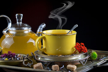 Sweet, hot tea with dry tea leaves, on an old background.