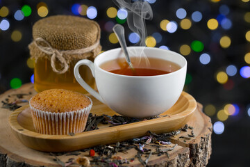 Sweet, hot tea with dry tea leaves, on an old background.