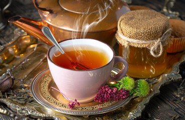 Dry tea leaves in a spoon on an old background