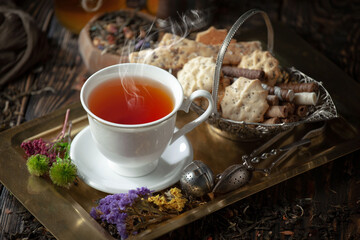 Dry tea leaves in a spoon on an old background