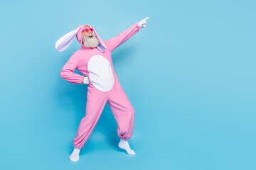 Full length photo of charming funky man pensioner dressed pink rabbit nightwear heart eyewear empty space isolated blue color background