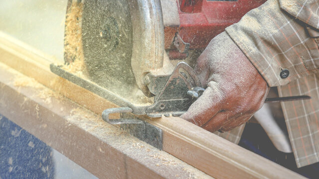 carpenter cutting wood with saw, carpenter is cutting wood into beautiful grooves using unsafe work machinery.