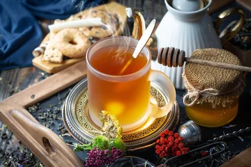 Sweet, hot tea with dry tea leaves, on an old background. © Karnav