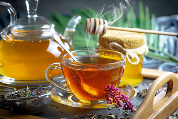 Sweet, hot tea with dry tea leaves, on an old background.