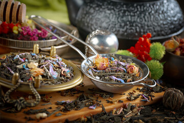Dried tea leaves in a spoon, on an old background.
