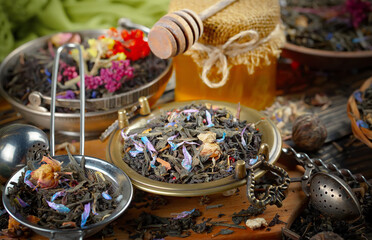 Dried tea leaves in a spoon, on an old background.