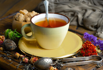 Sweet, hot tea with dry tea leaves, on an old background.